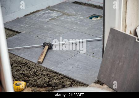 Mallet and tools on granite tile during laying floor Stock Photo