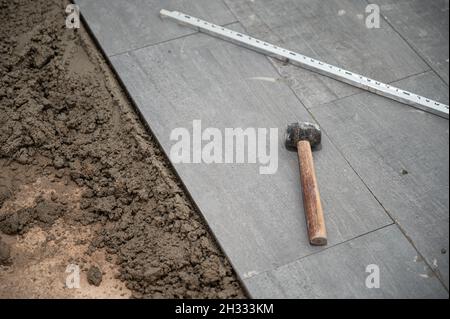 Mallet and tools on granite tile during laying floor Stock Photo