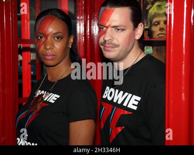 London, UK. 25th Oct, 2021. London, UK, October 25th. A pop up store is opening in Heddon Street to mark what would have been his 75th birthday offering David Bowie items. Two members of staff with Ziggy Stardust makeup pose in the iconic phone booth. Credit: Uwe Deffner/Alamy Live News Stock Photo