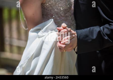 Shallow focus shot of a newly married couple holding hands Stock Photo