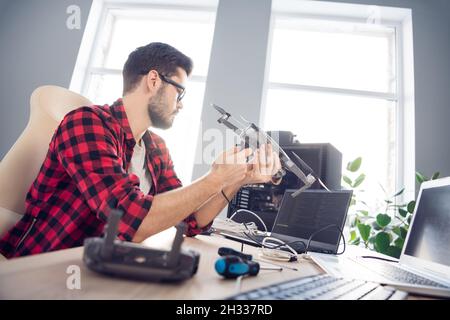 Profile side view portrait of attractive clever focused guy fixing drone bug software detail programming code at work place station indoors Stock Photo
