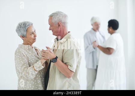 Affectionate elderly couple learning to dance together in dance studio Stock Photo