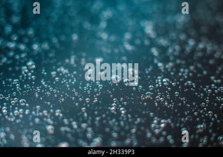 Dark blue background of air bubbles on the water surface. Close-up shot of air bubbles in liquid. Selective focus. Stock Photo