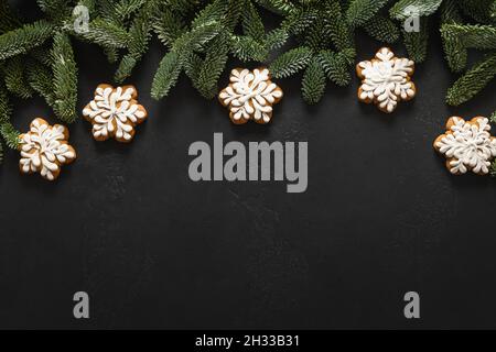 Christmas glazed cookies as snowflakes on black background. Happy New Year. View from above. Flat lay. Copy space Stock Photo