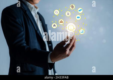 Businessman holding a bright light bulb. Stock Photo