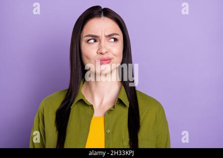 Photo of sweet doubtful young woman wear khaki outfit looking empty space isolated violet color background Stock Photo