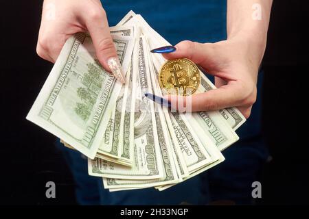 Close-up womans hands hold money and bitcoin. Stock Photo