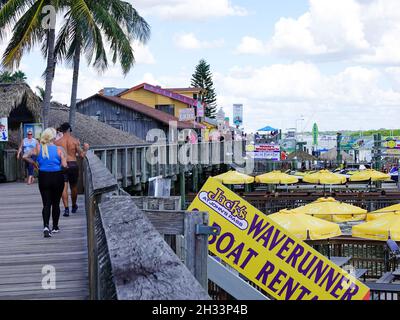 People on the boardwalk passing shops and restaurants at John’s Pass Village on Madeira Beach, Florida, USA. Stock Photo