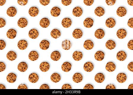 Chocolate chip cookie pattern on a white background. Lots of brown baked cookies, filled with chocolate. Stock Photo