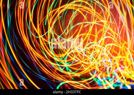 Dynamic abstract background, lines of colored lights in a messy and vibrant spiral. Stock Photo