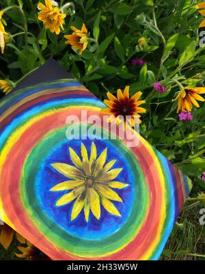 Abstract painting by oil on canvas in the summer park. Yellow rudbeckia flower and rainbow circles. Stock Photo