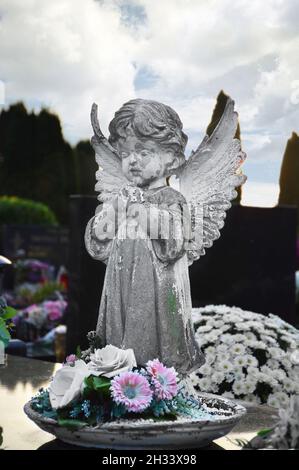 Praying angel figurine on the grave Stock Photo