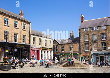 People in the historic Market Square and Market cross Market Place  Alnwick town centre Alnwick Northumberland Northumbria England UK GB Europe Stock Photo