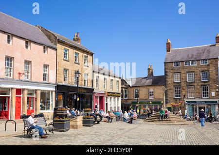 People in the historic Market Square and Market cross Market Place  Alnwick town centre Alnwick Northumberland Northumbria England UK GB Europe Stock Photo