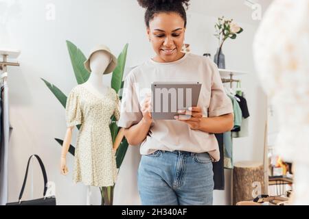 Local clothing store owner standing with digital tablet Stock Photo