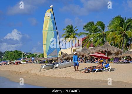 Tourists sunning on sandy beach of Rodney Bay, Gros Islet District on the island of Saint Lucia in the Caribbean Sea Stock Photo