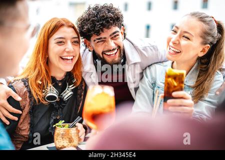 Young people having fun drinking at open air bar after work - Life style concept with trendy guys and girls enjoying time together sharing cocktails Stock Photo