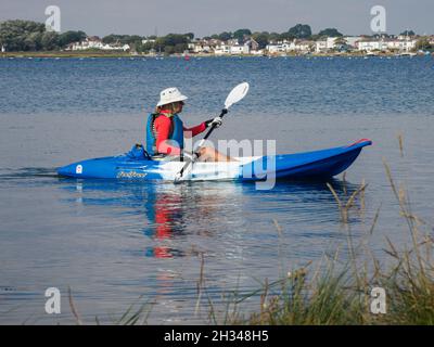 Middle aged woman kayaking on the Christchurch Harbour, Dorset, UK Stock Photo