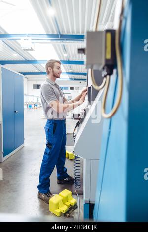 Manufacturing worker programming industrial CNC machine tool Stock Photo