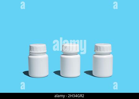 Three plastic medical bottles on a blue background Stock Photo