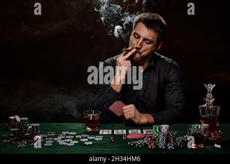 Bearded casino player man playing poker on green table Stock Photo