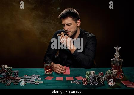 Bearded casino player man playing poker on green table Stock Photo