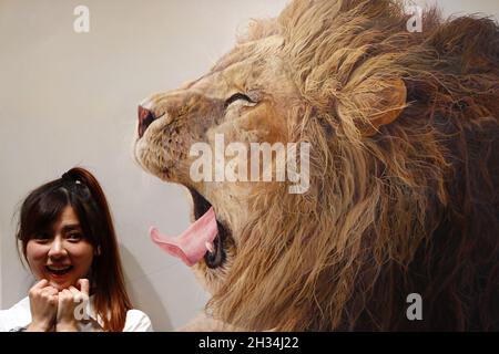 Taipei, Taipei, Taiwan. 25th Oct, 2021. A girl poses for a picture with a lion painting, at the Art Taipei Expo 2021. The exhibition comprises of 124 artwork from across the world including Taiwan, US, UK and some other European countries. (Credit Image: © Daniel Ceng Shou-Yi/ZUMA Press Wire) Stock Photo