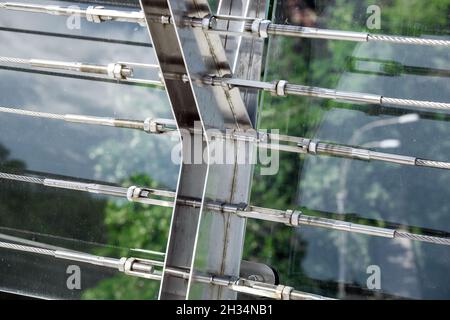 lock sling steel and screw a close up view of detail of clamps system on glass bridge with tensioners engineering construction stainless steel turnbuc Stock Photo