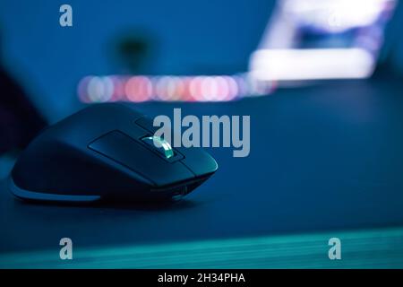 Close-up of black gaming computer mouse laying on dark table. Selective focus. Professional computer game playing, esport business and online world co Stock Photo