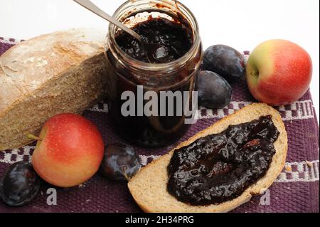 Delicious fruit jam made of plums and apples spread on a piece of homemade bread Stock Photo