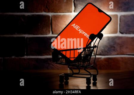 AliExpress is an Chinese online retail service. Smartphone with AliExpress logo on screen in the shopping cart. Stock Photo