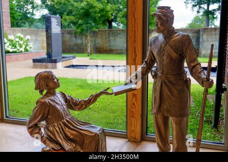 Sculpture of black Union soldier handing book to freed slave girl inside the Corinth Civil War Interpretive Center of Shiloh National Military Park in Stock Photo