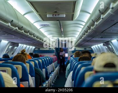 Selective shot of a saloon of the aircraft with passengers during the flight Stock Photo