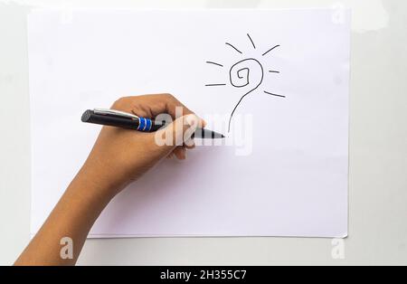 Top close up above overhead view photo of left-hand child holding wooden pen starting to draw a picture isolated white paper color background Stock Photo