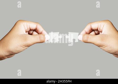 Close up holding one puzzle element wrong or not connected isolated on gray background. High-resolution product. Stock Photo