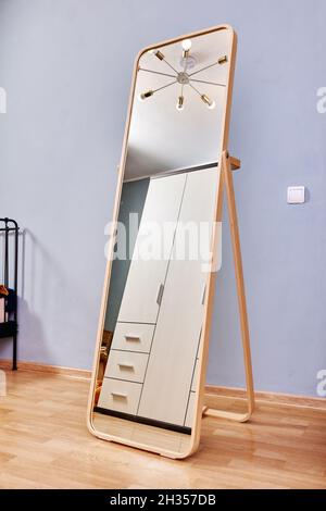 Growth mirror stands in bedroom on laminate floor. Stock Photo