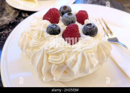 Pavlova, meringue dessert with a crisp crust and soft, light inside, topped with raspberries and blackberries, Plzen, Czechia Stock Photo
