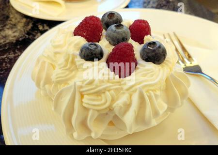 Pavlova, meringue dessert with a crisp crust and soft, light inside, topped with raspberries and blackberries, Plzen, Czechia Stock Photo