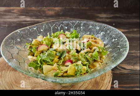 Green salad of hasa, arugula and rocket with mushrooms, avocado and pears. French gourmet cuisine. Stock Photo
