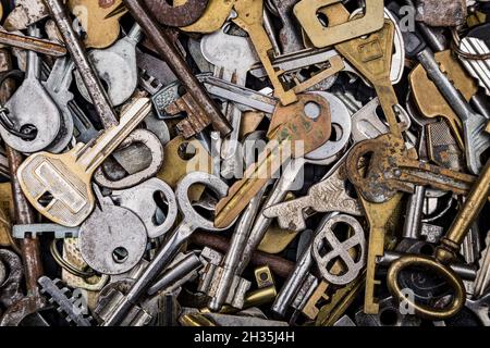 Background of assorted old multi-colored metal antique keys of different shapes. Home security concept. Stock Photo