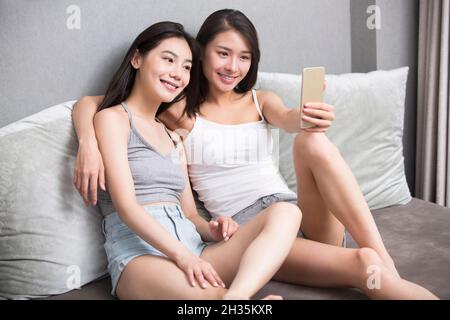 Two best friends taking selfies on a mobile phone Stock Photo
