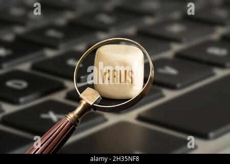 A computer, magnifying glass and virus Stock Photo
