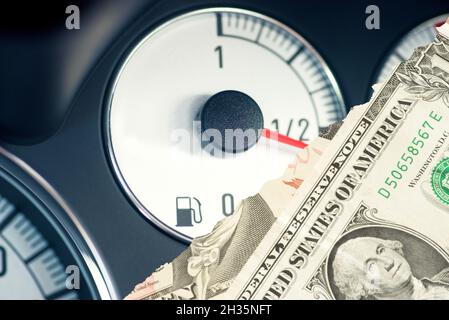 Fuel gauge in a car and dollar bills Stock Photo