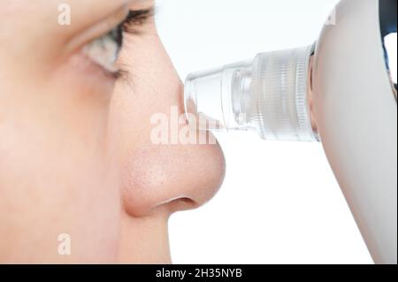 Woman cleaning nose from blackheads with suction tool isolated Stock Photo