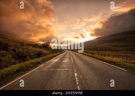 Sunrise on the A4086 between Capel Curig and Pen-y-Pass in Snowdonia National Park, Wales UK Stock Photo