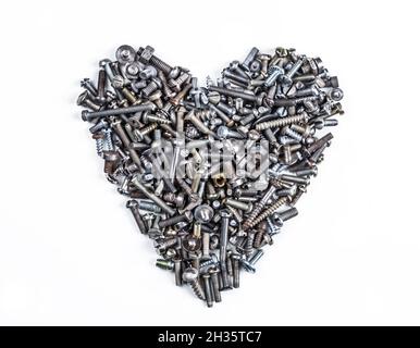 A heart shaped figure laid out from various assorted rusty metal old bolts, screws, nails, nuts. The concept of metallic artificial heart machine, rob Stock Photo