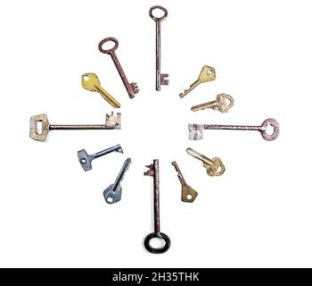 Many assorted old multi-colored metal antique keys of different shapes laid out in circle isolated on white background. Home security concept. Copy sp Stock Photo