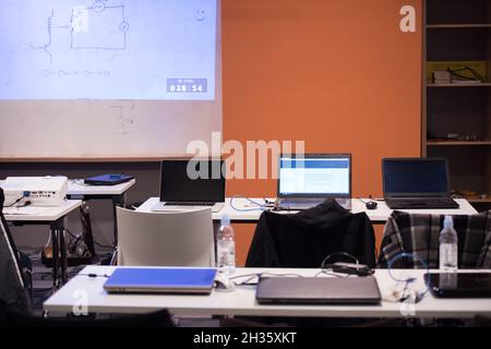 empty it classroom with program code on projector screen and modern laptop computers on table Stock Photo