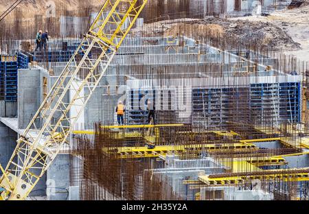 Construction workers install formwork and iron rebars or reinforcing bar for reinforced concrete partitions at the construction site of a large reside Stock Photo