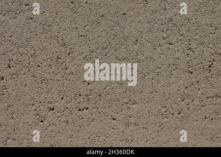 Street wall with plaster. Plaster of beige color with holes. Wall texture. Stock Photo